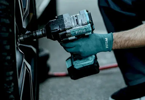 Hombre utilizando una llave de impacto Total en un neumático